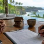 A real estate agent and expat investor signing a notarized leasehold contract on a modern outdoor terrace with a tropical villa and swimming pool in the background.